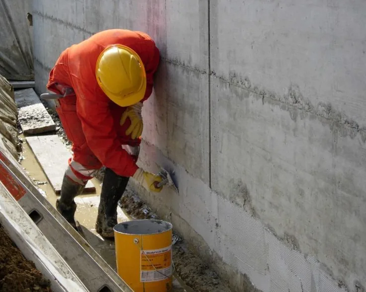 Tukang ASATURA melabur dinding beton dengan waterproofing berbahan semen
