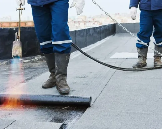 Tukang ASATURA membakar gulungan membran bitumen agar melekat ke dak
