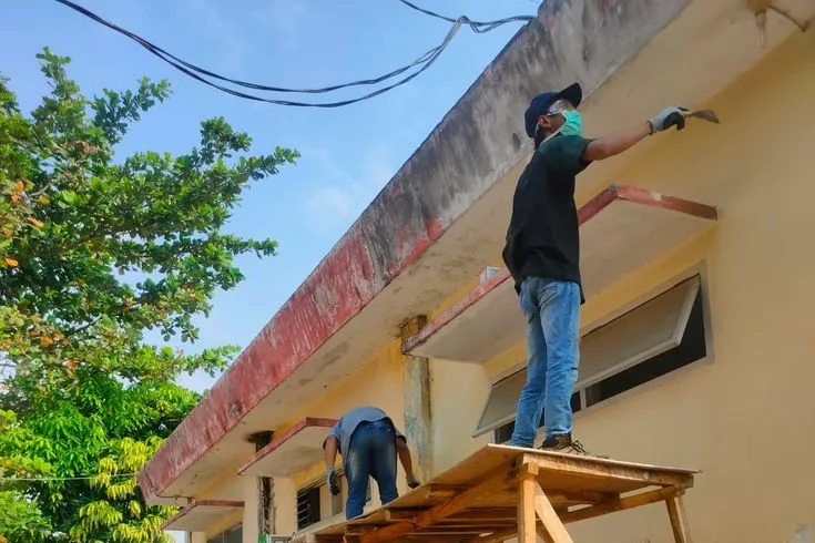 Pengecatan ulang dinding gedung lama yang catnya sudah mengelupas di Jakarta Utara