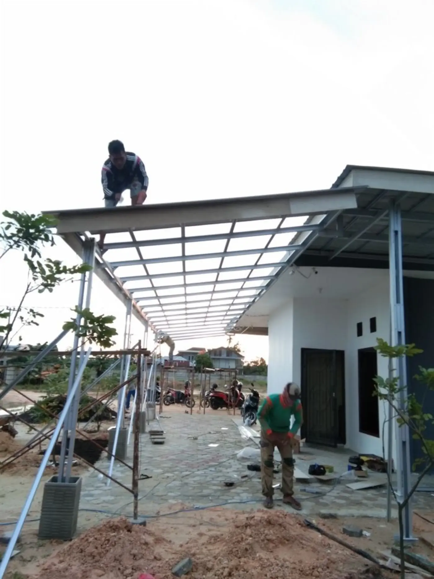 Tim ASATURA memasang rangka kanopi carport di rumah
