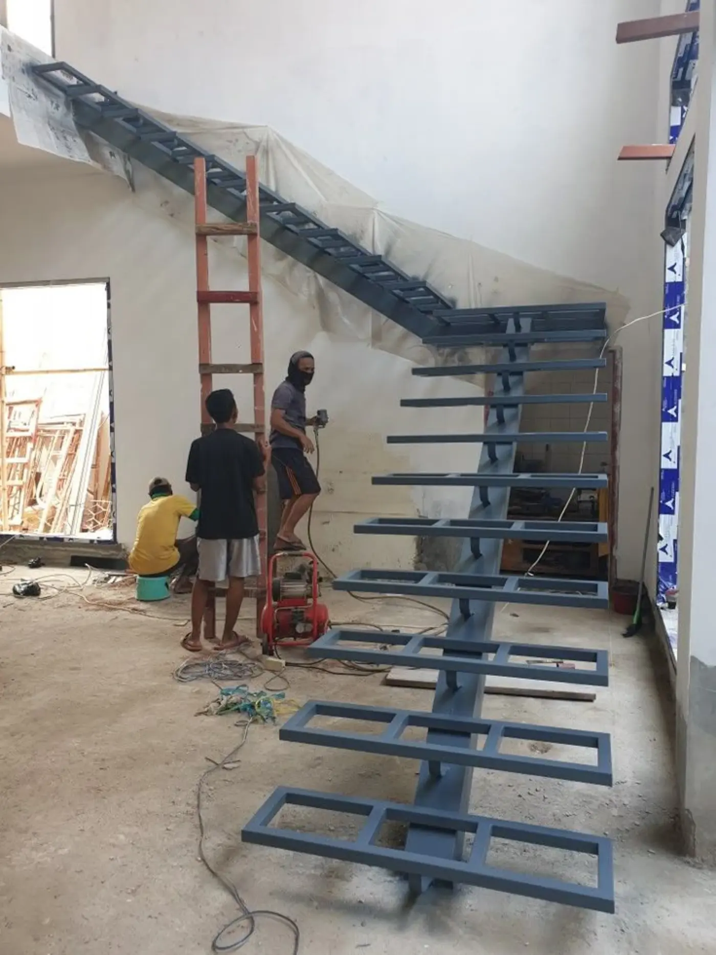 Tukang las ASATURA mengerjakan railing tangga besi custom